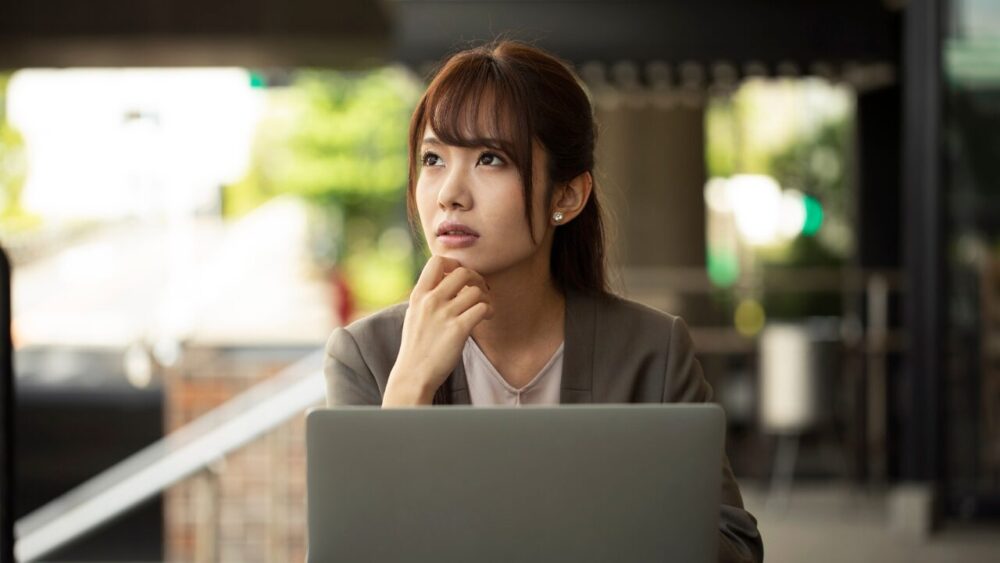 考える女性-リフォームを費用を抑えようと考えている様子